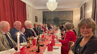 Pensjonister rundt et pyntet julebord i stor sal